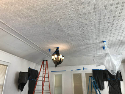Decorative pressed tin ceiling tiles installed and masked for painting