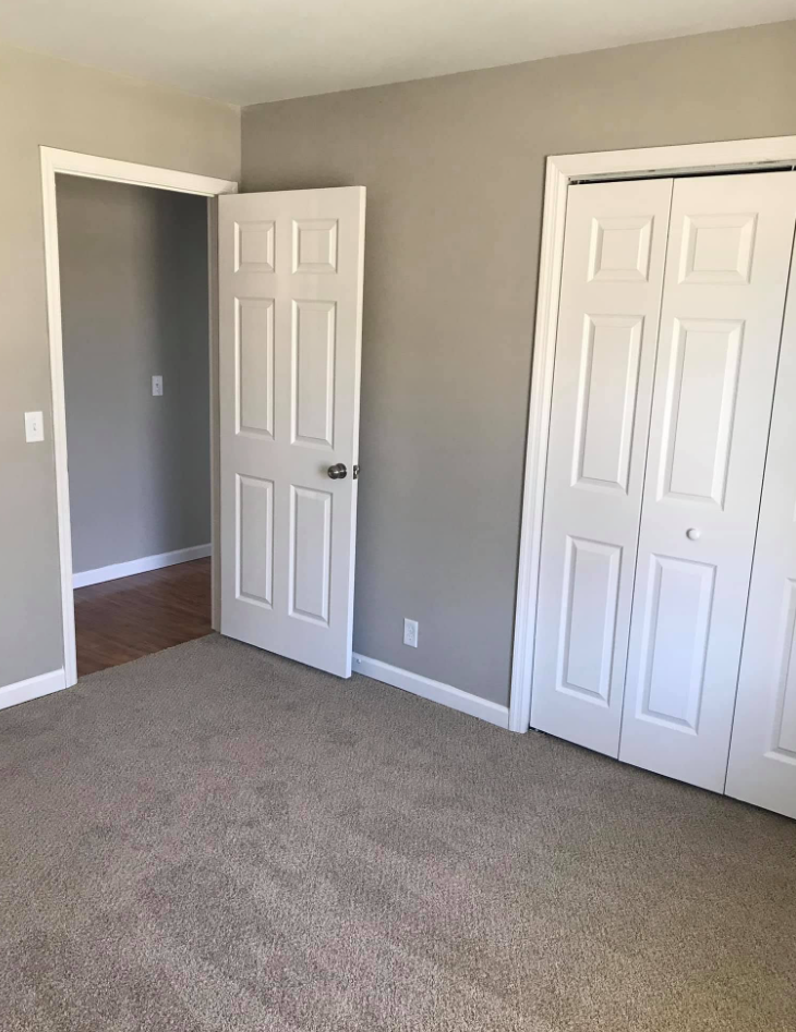Freshly painted bedroom with new carpet, six-panel door and bifold closet doors