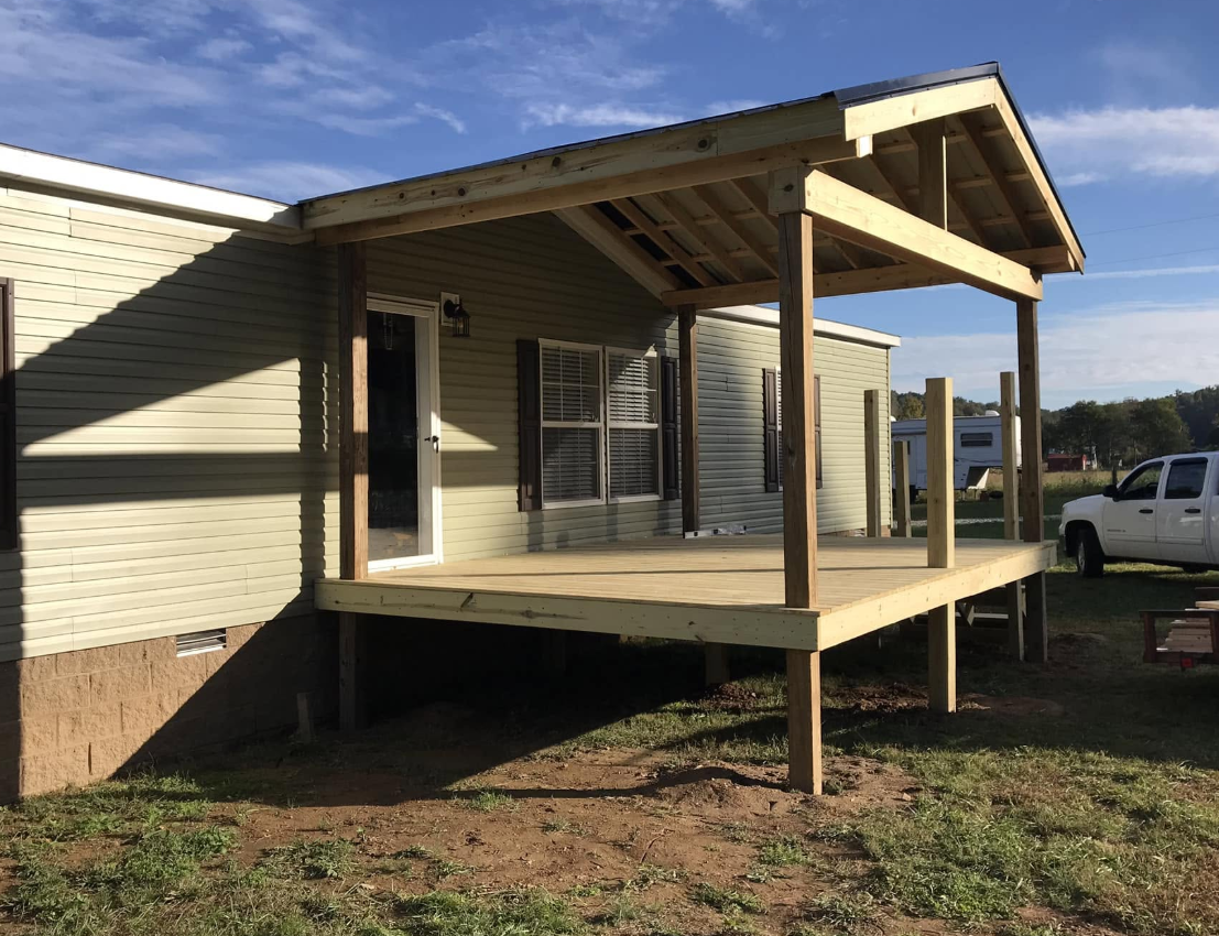 New covered porch addition with gable roof and treated posts on a Tennessee home